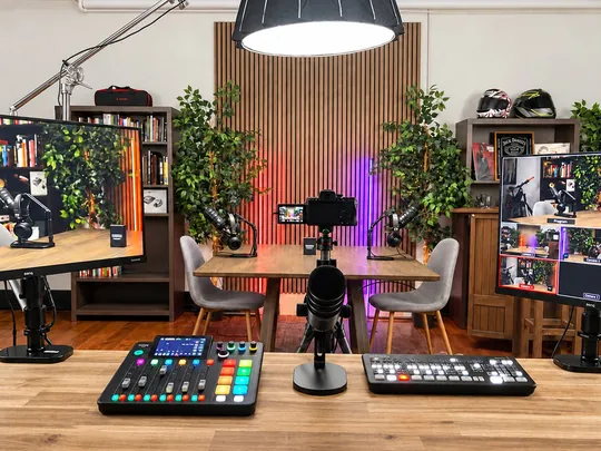 The Effective Not Famous studio: a table with two chairs, microphones, screens and the mixing desk